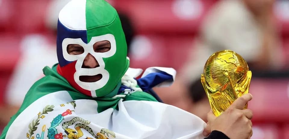 Fan wearing mask holds World Cup trophy