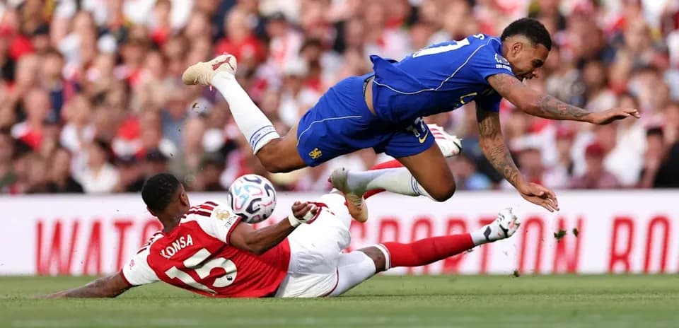 Player falling over opponent during football match