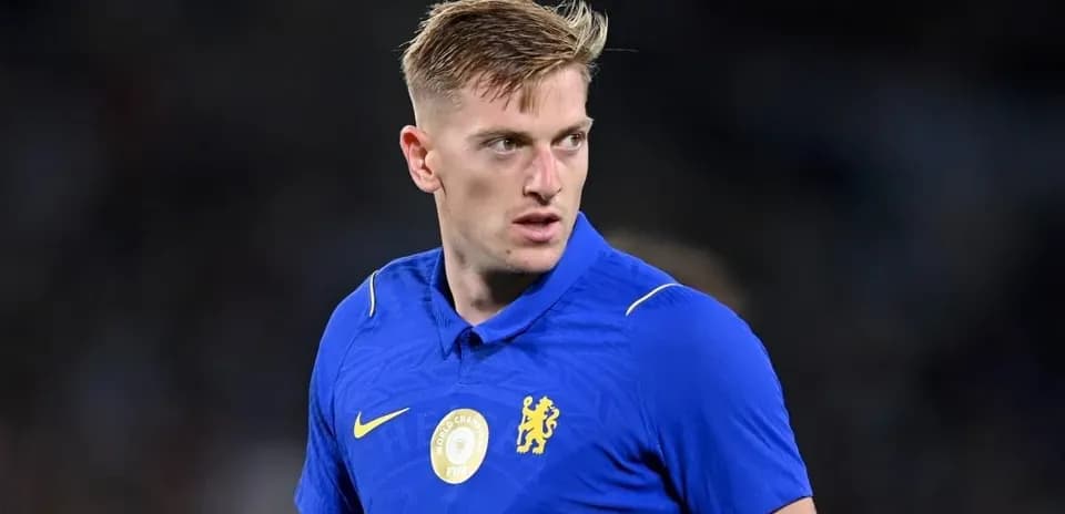 Futbolçu mavi forma ilə sahədə dayanıb