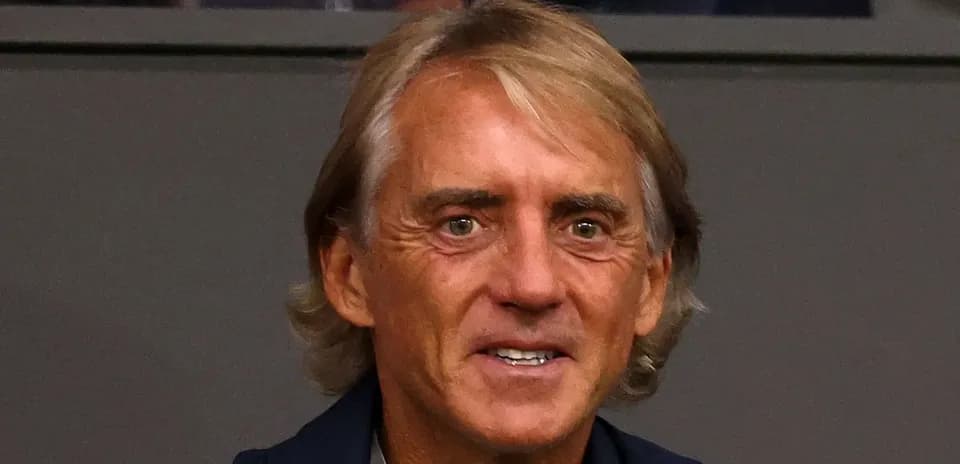 Coach smiling while watching the match from stands