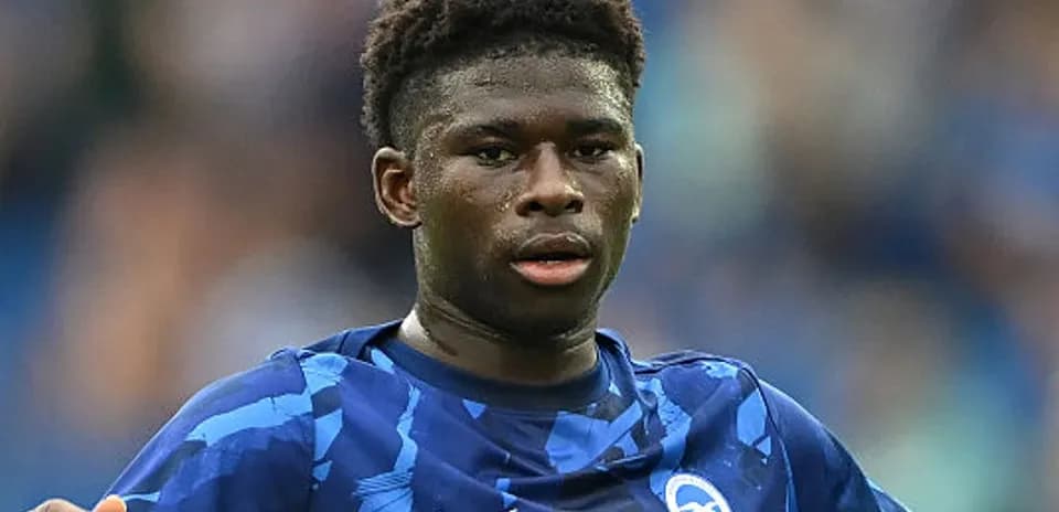Futbolçu mavi forma ilə meydanda oynayır