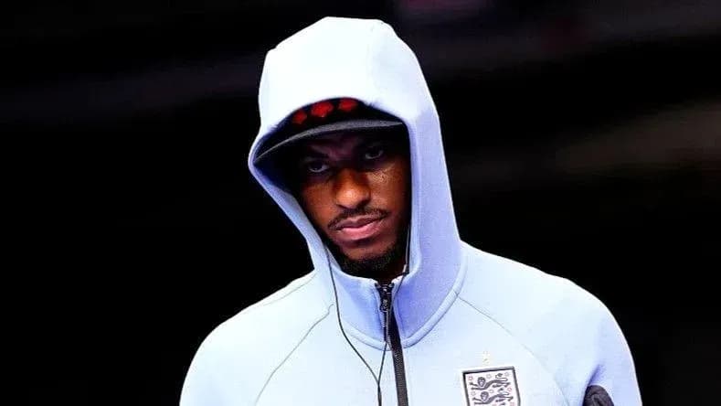 Player entering stadium wearing a hooded sweatshirt