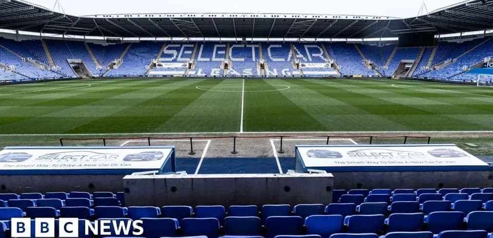 Boş stadion, mavi oturacaqlar və yaşıl meydan