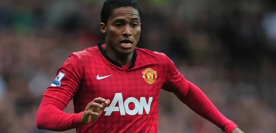 Futbolçu Manchester United formasında topa doğru qaçır