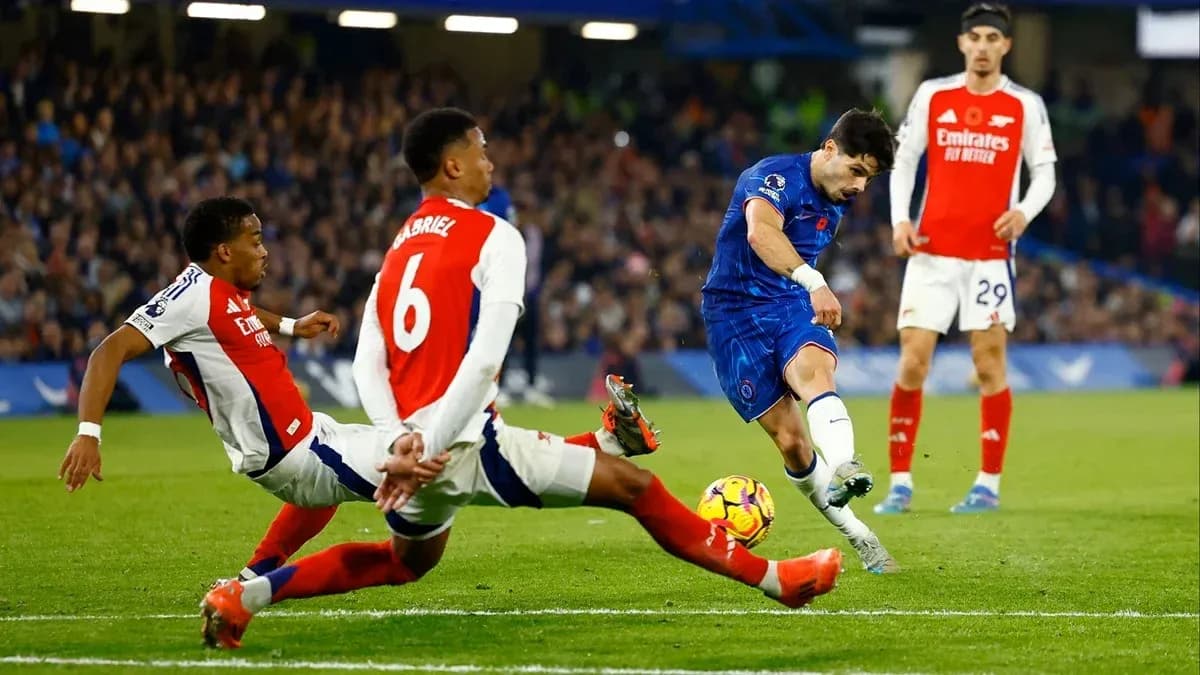 Chelsea player attempting to score against Arsenal defenders