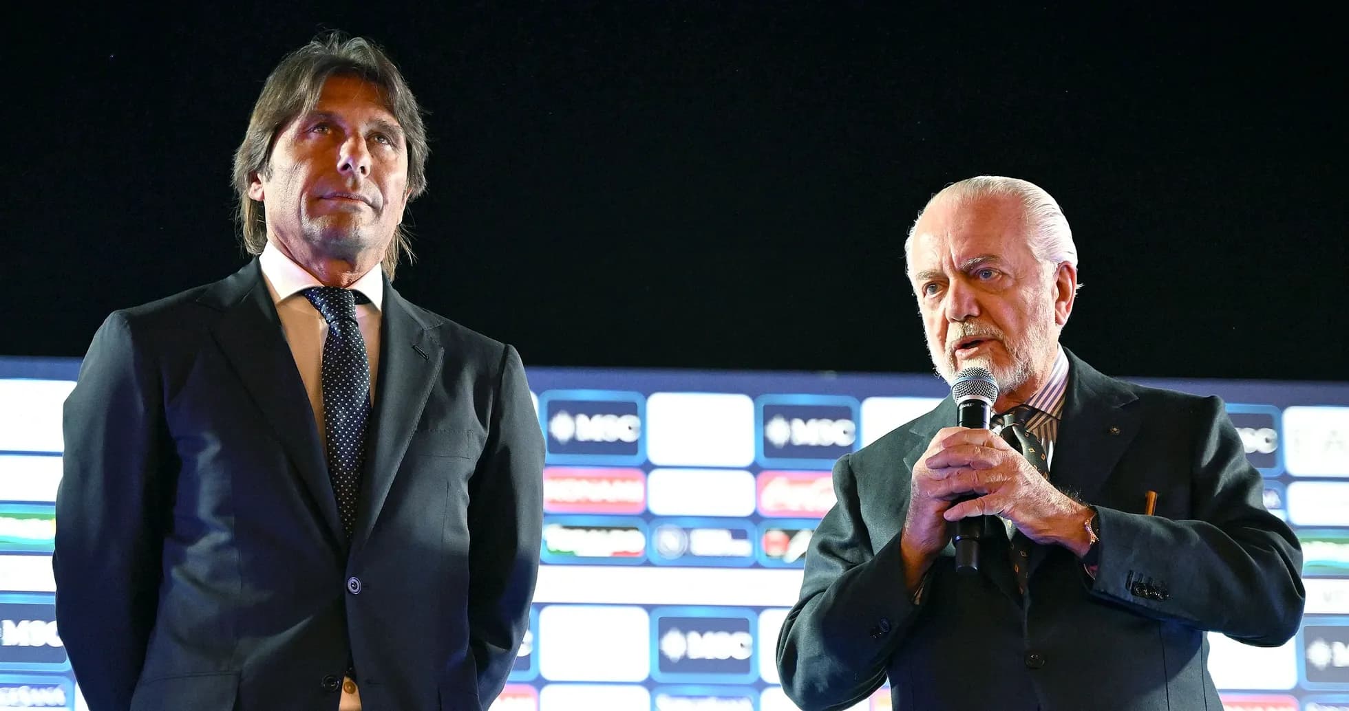 İki kişi tədbirdə mikrofonla danışır