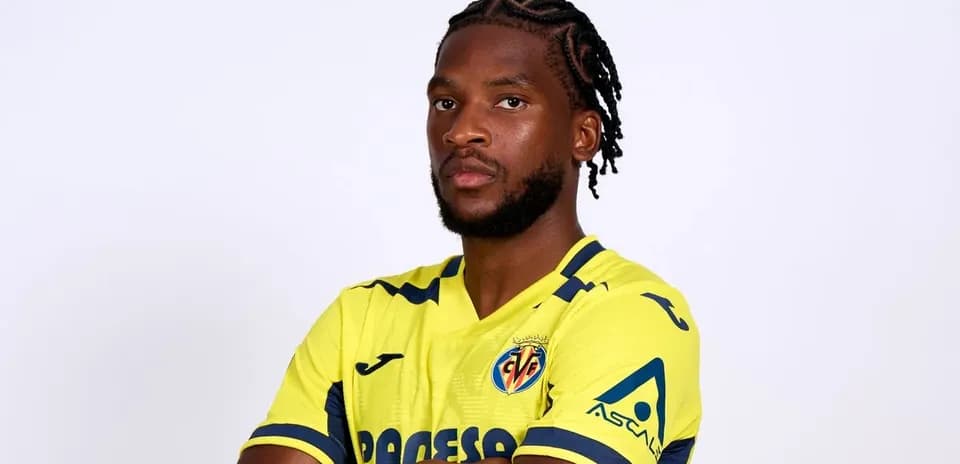 Futbolçu sarı forma ilə poz verərək durur