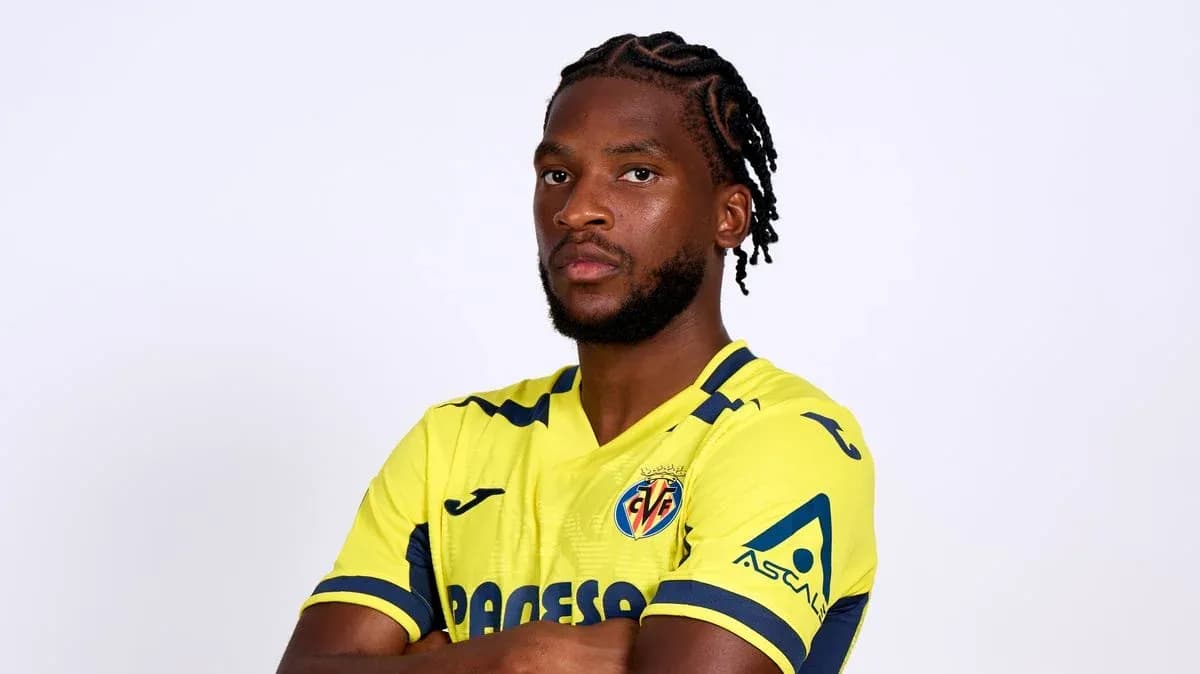 Futbolçu sarı forma ilə poz verərək durur