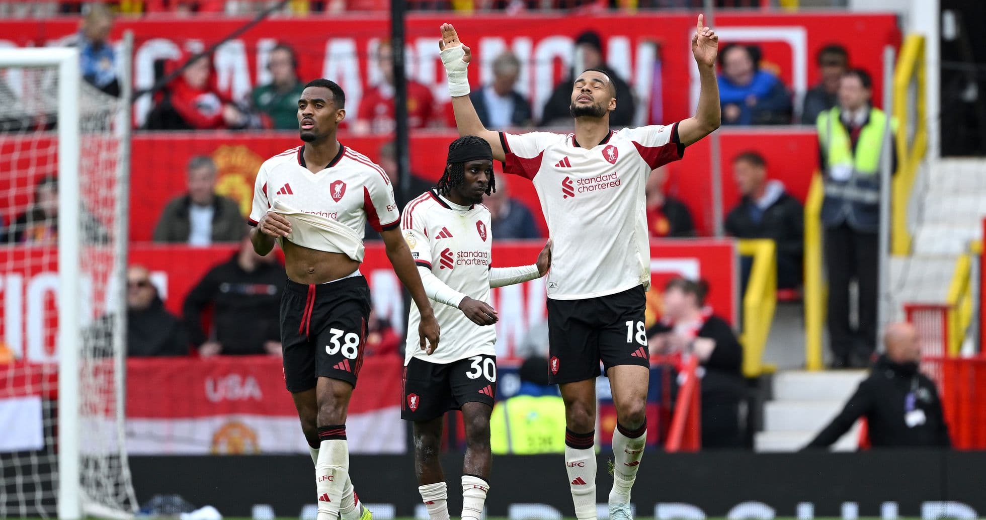 Three players celebrating during a match at Old Trafford