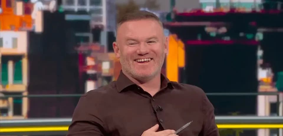 Analyst smiling while holding a pen on set