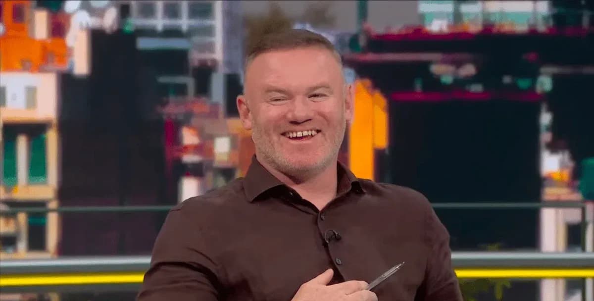 Analyst smiling while holding a pen on set