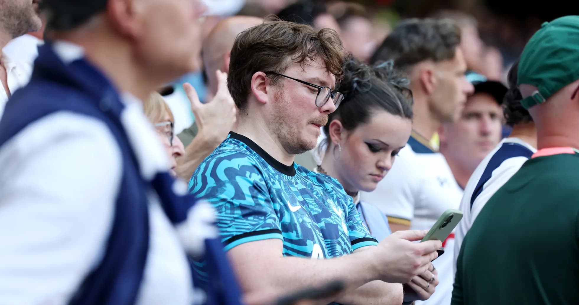 Fans focused on their phones during the match
