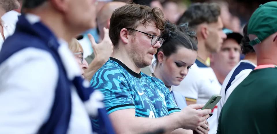 Fans focused on their phones during the match