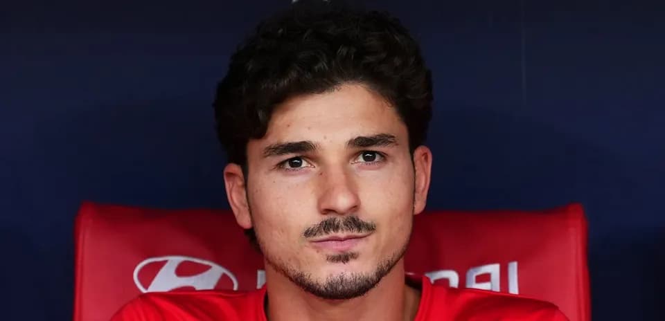 Futbolçu qırmızı köynəkdə oturur benchdə