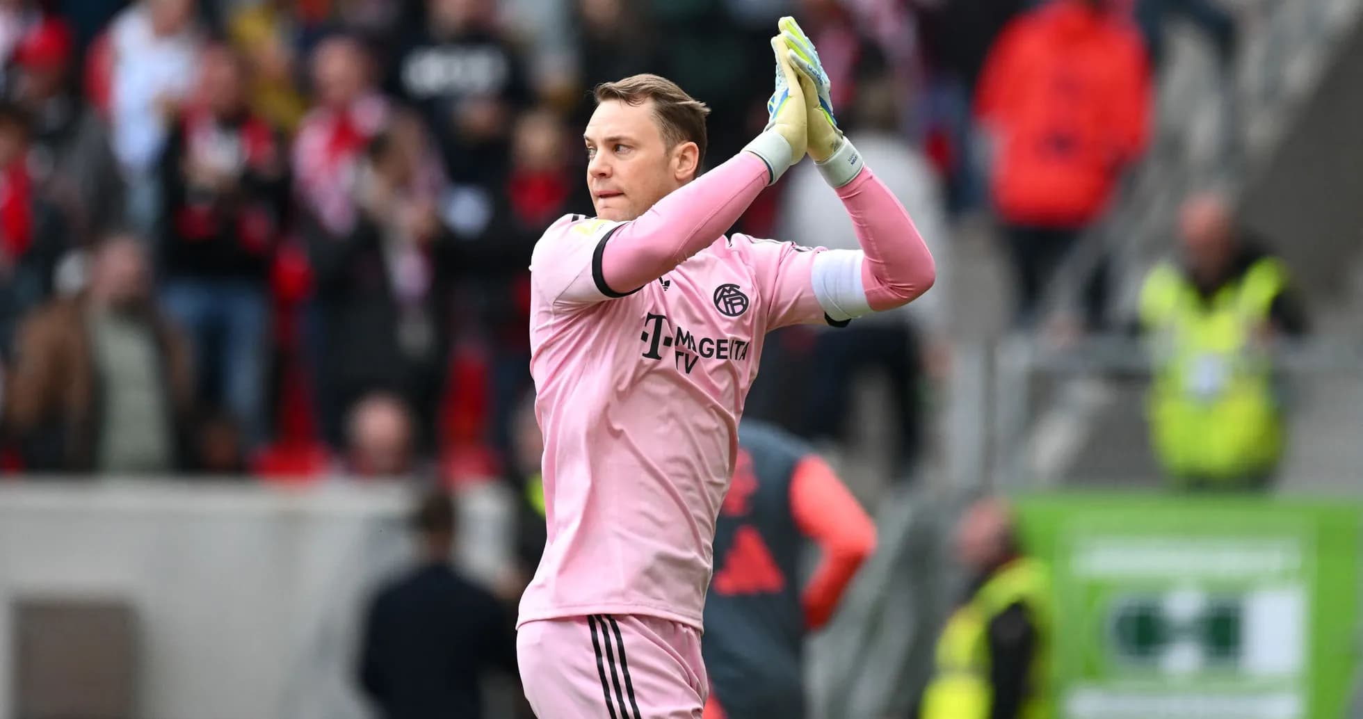 Goalkeeper clapping to fans in pink kit