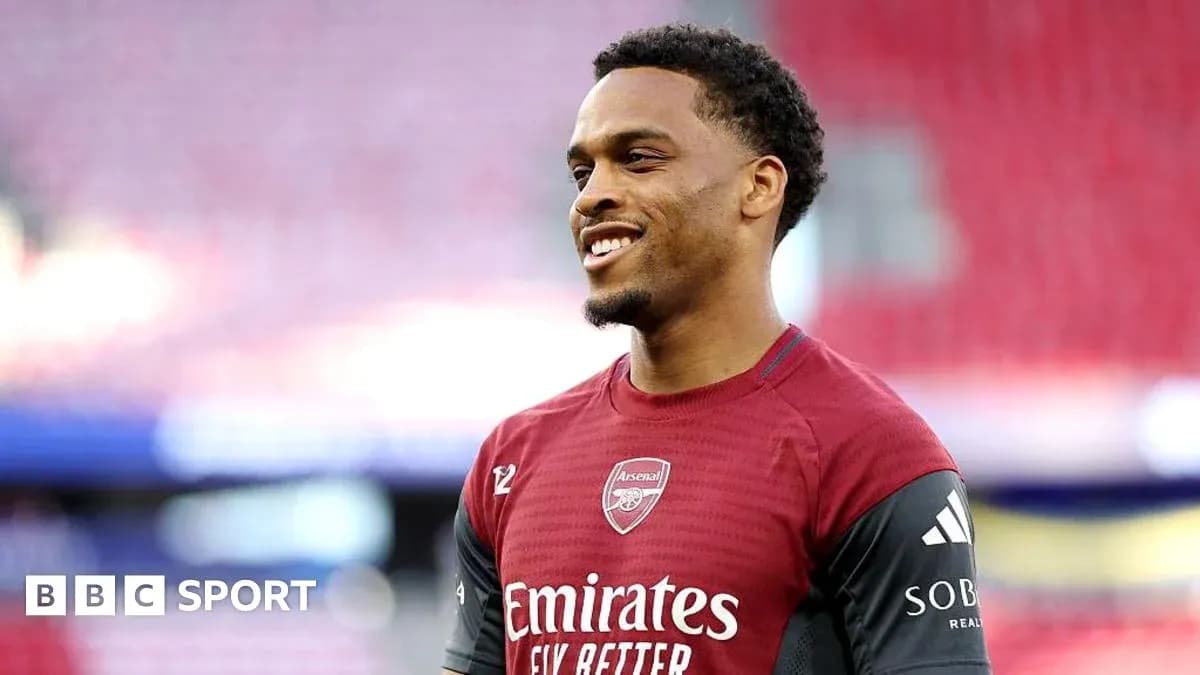 Futbolçu Arsenal formasında gülərək durur