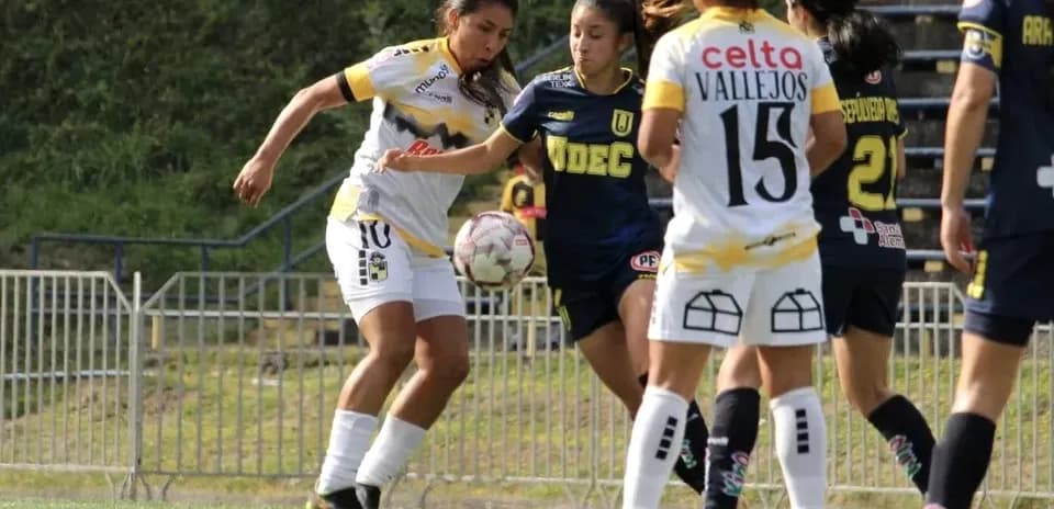 İki qadın futbolçu top uğrunda mübarizə aparır
