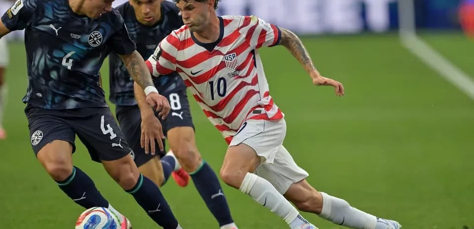 Christian Pulisic dribbling past opposing players during match