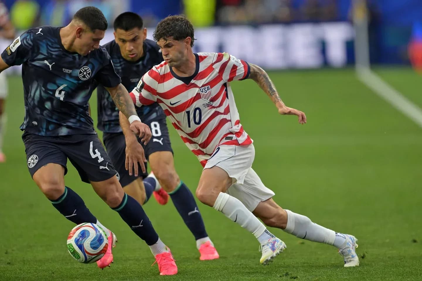 Christian Pulisic dribbling past opposing players during match