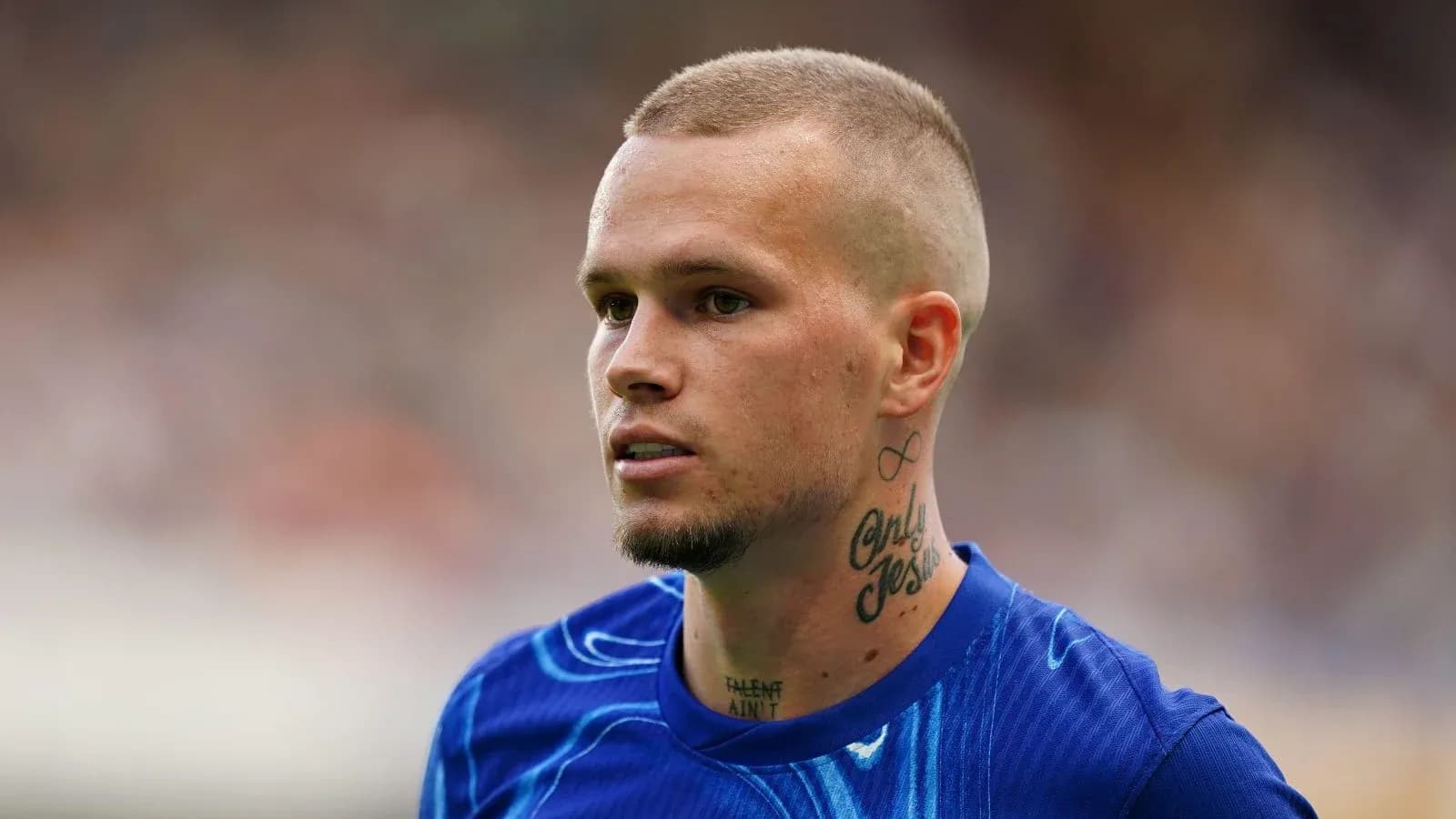 Futbolçu mavi forma ilə meydanda durur