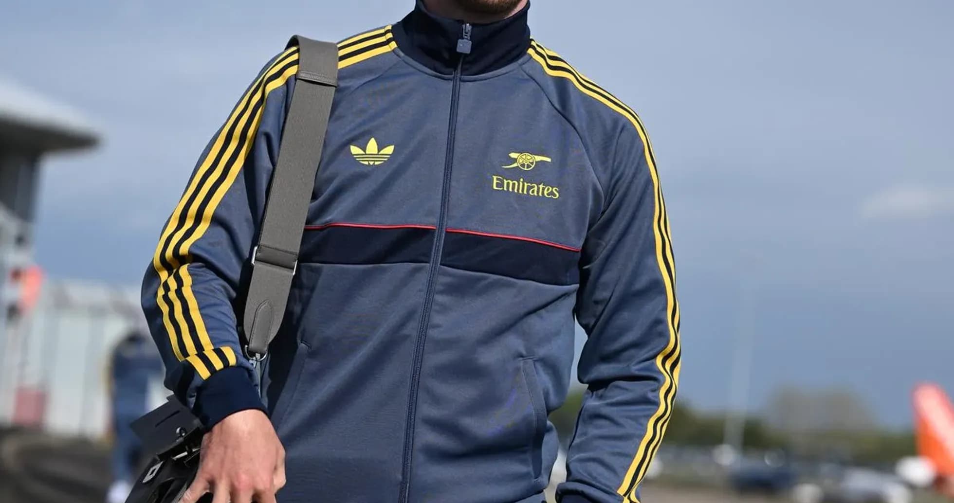 Athlete in tracksuit walking with a bag
