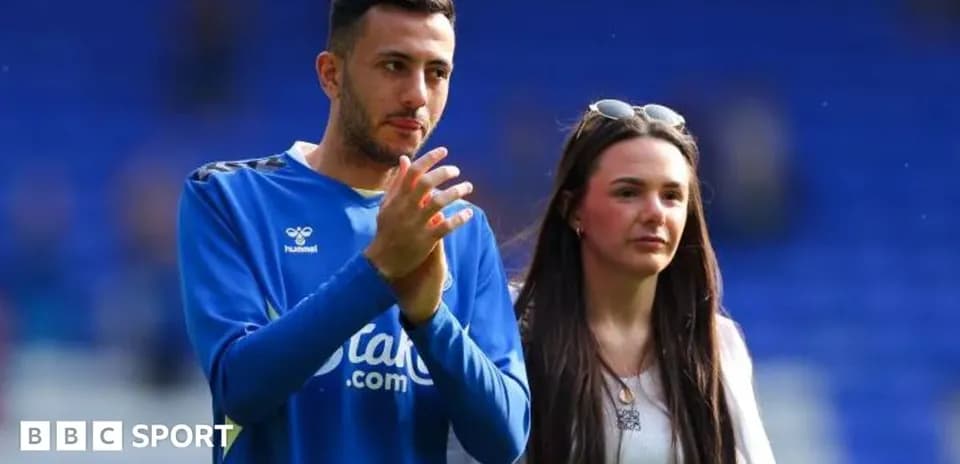 Football player and companion on pitch after match