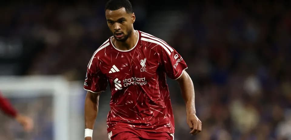 Futbolçu Liverpool forması ilə topa yaxınlaşır