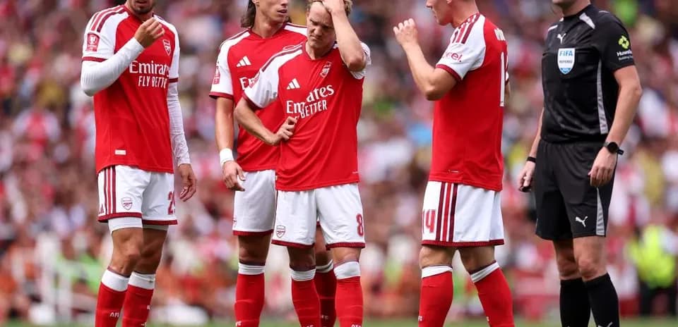 Arsenal players discussing during a match with referee