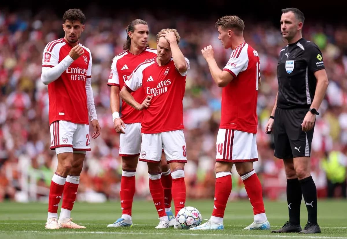 Arsenal players discussing during a match with referee