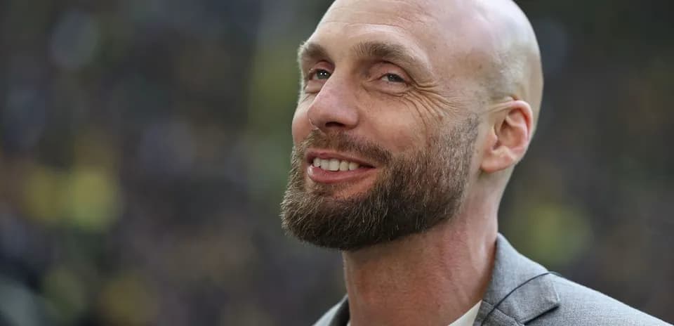 Bald man with beard smiling in a suit