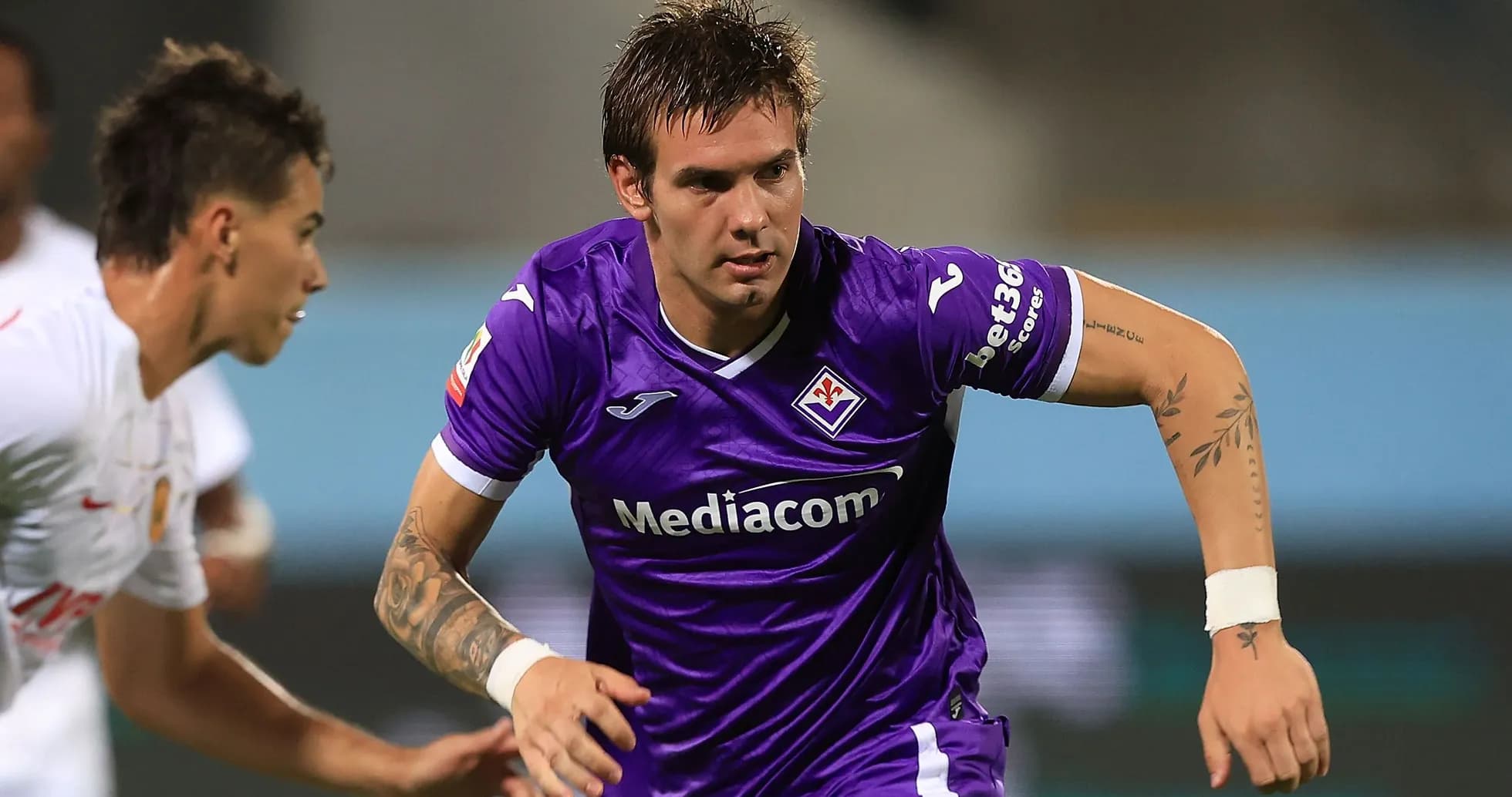 Fiorentina player dribbling past opponent during match