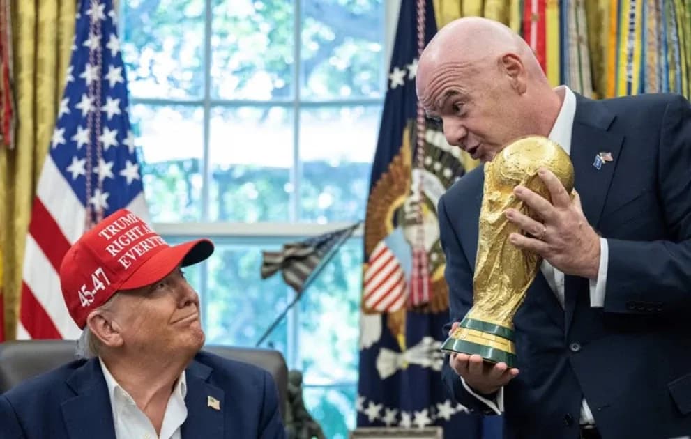 Two men discussing FIFA World Cup trophy in office