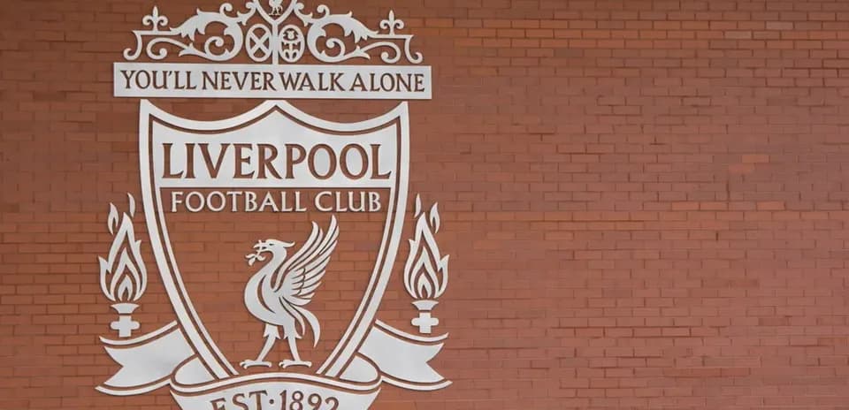 Liverpool FC crest on red brick wall