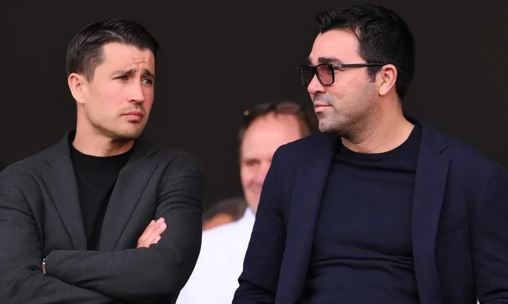 Two men conversing in a sports venue