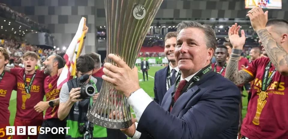 Coach holding UEFA Europa League trophy with team