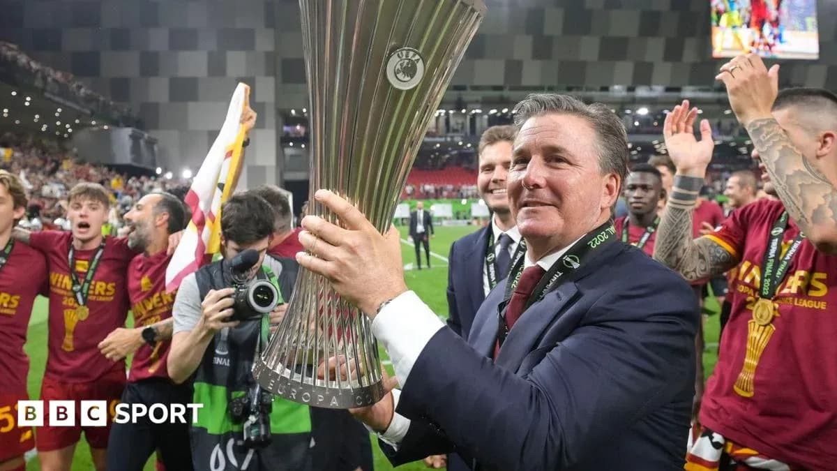 Coach holding UEFA Europa League trophy with team