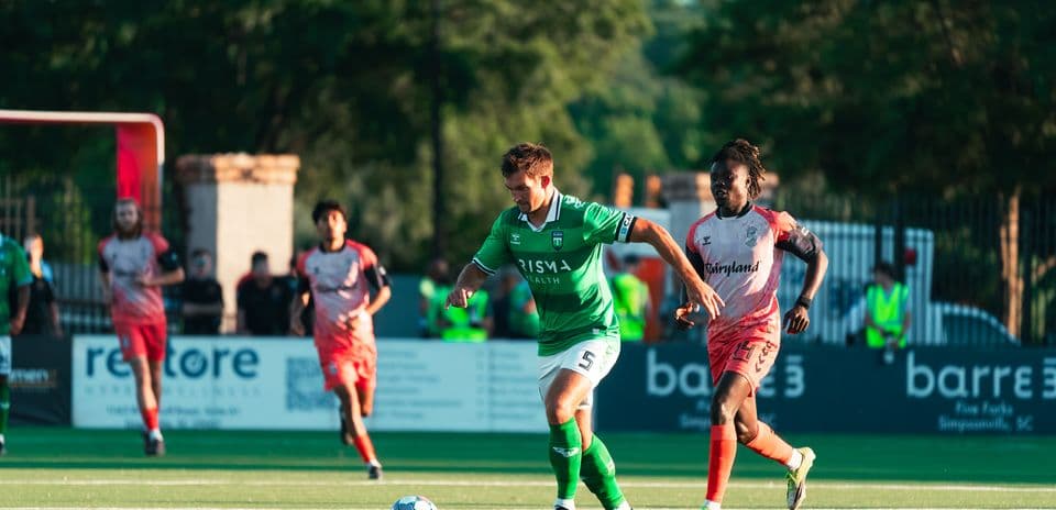 Greenville Triumph futbolçusu topu idarə edir