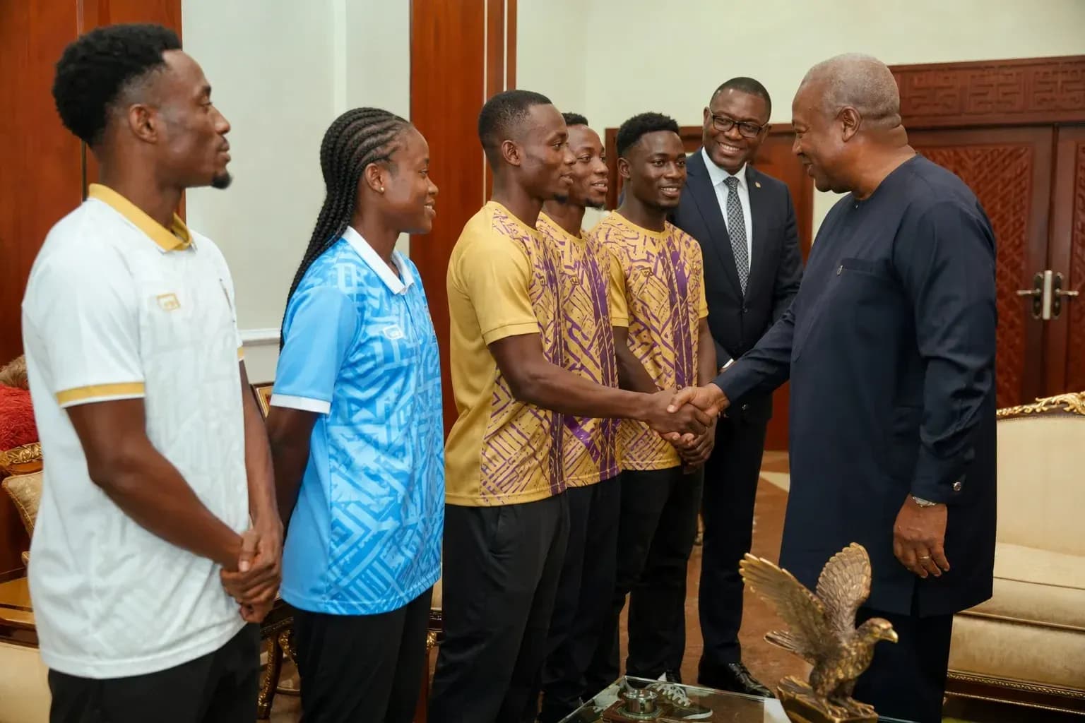 Athletes meeting with official in formal setting