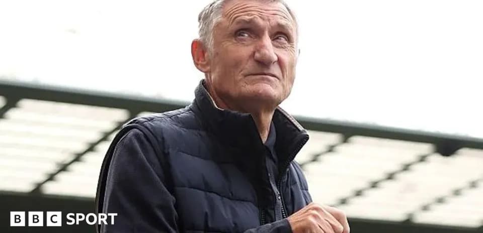 Elderly man holding a bottle at stadium
