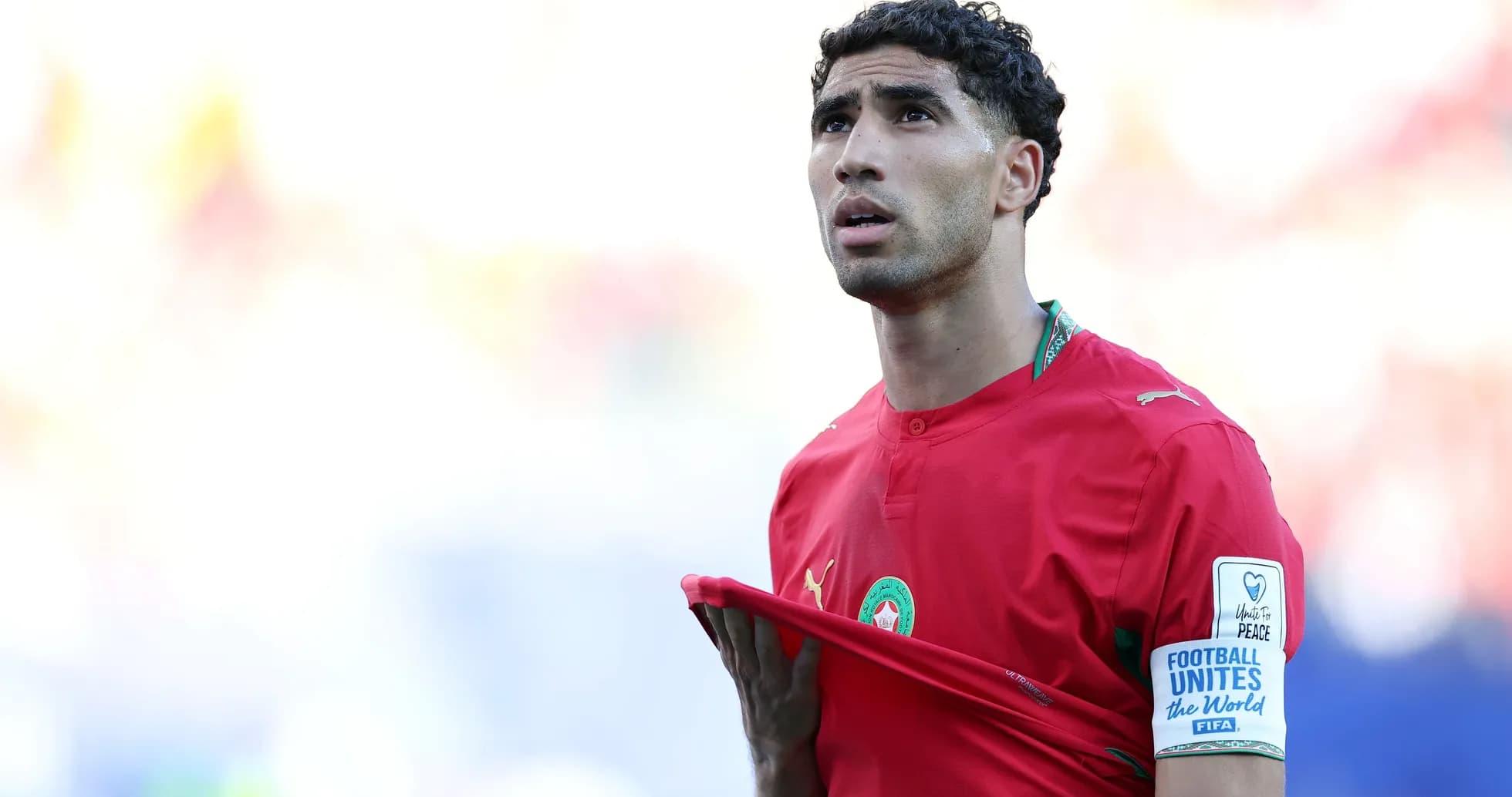 Futbolçu qırmızı forma ilə meydanda durur