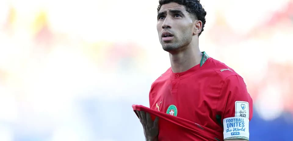 Futbolçu qırmızı forma ilə meydanda durur