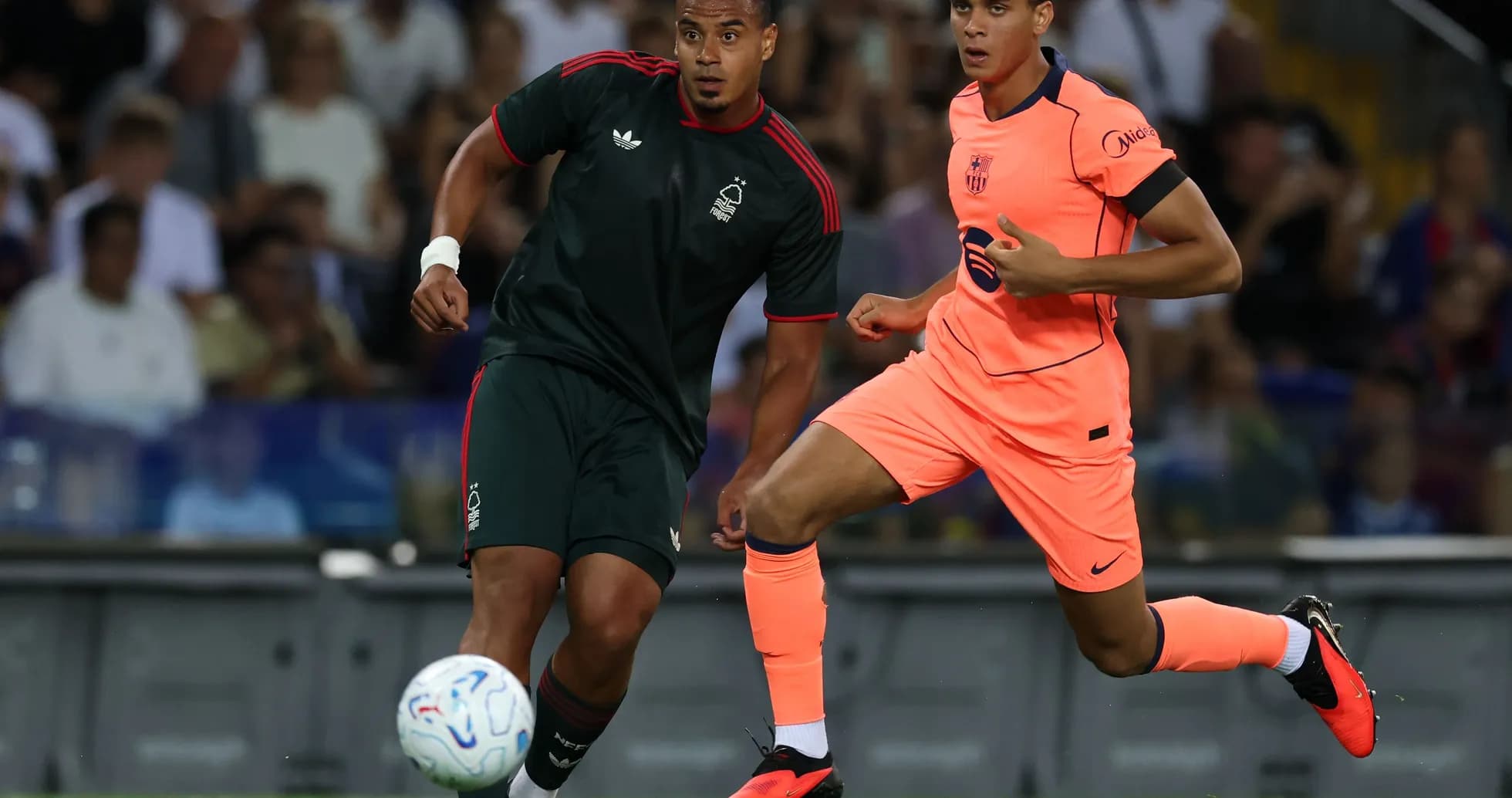 İki oyunçu top üçün yarışır, futbol matçı