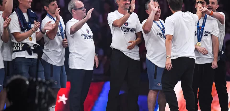 Coaching staff celebrating with medals on stage