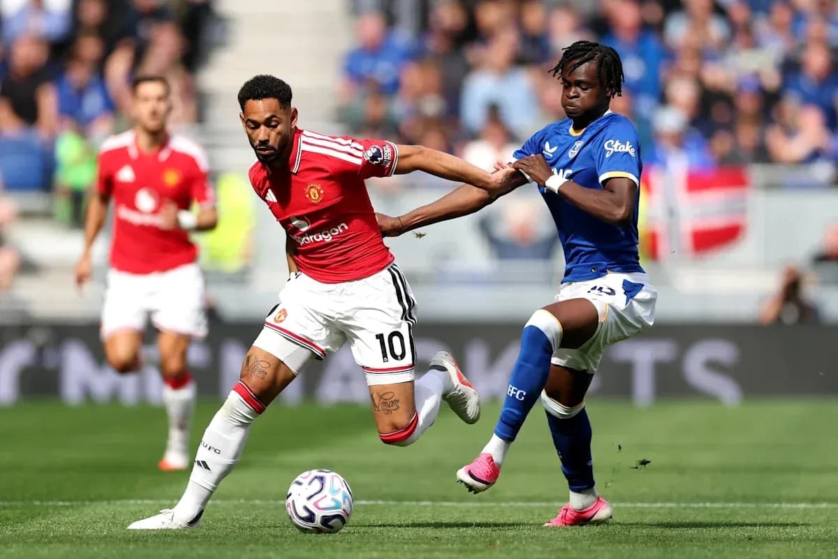 Manchester United player dribbling past Everton defender