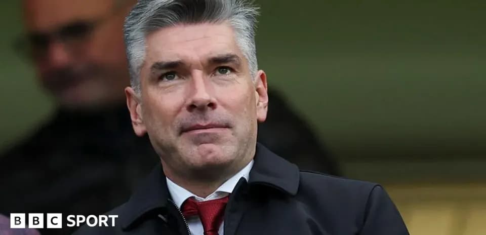 Man in suit observing from the stands at stadium