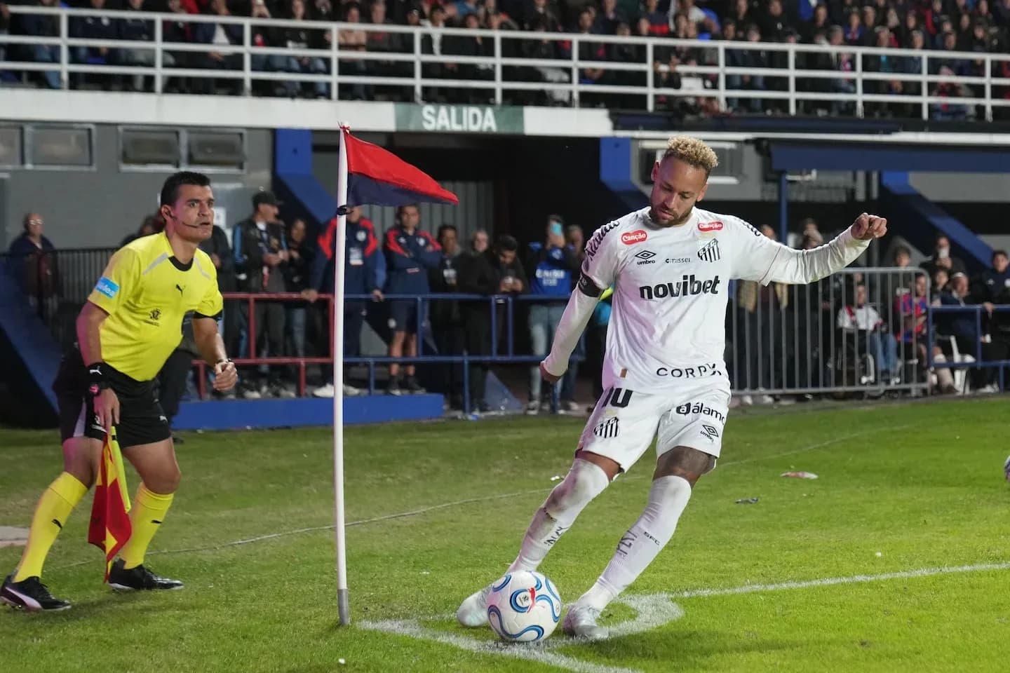Futbolçu künc zərbəsi atır, hakim izləyir