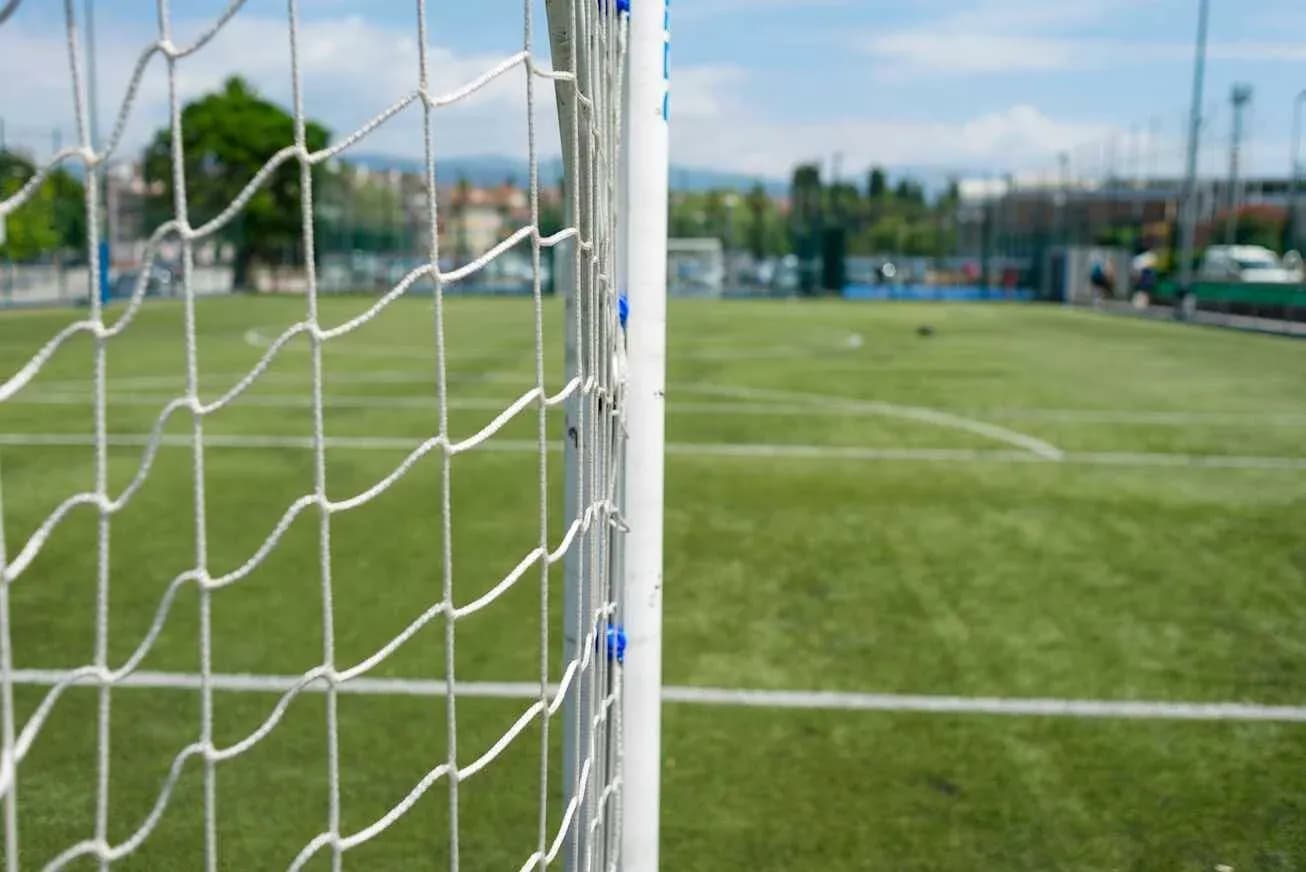 Futbol qapısının yanında yaşıl meydan görünür
