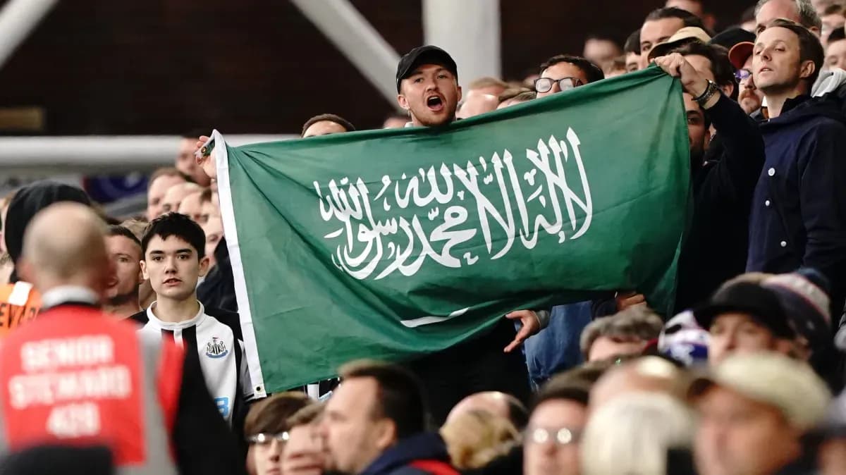 Fan holding Saudi Arabia flag in stadium crowd