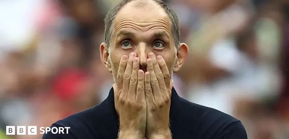 Coach covering face with hands during match