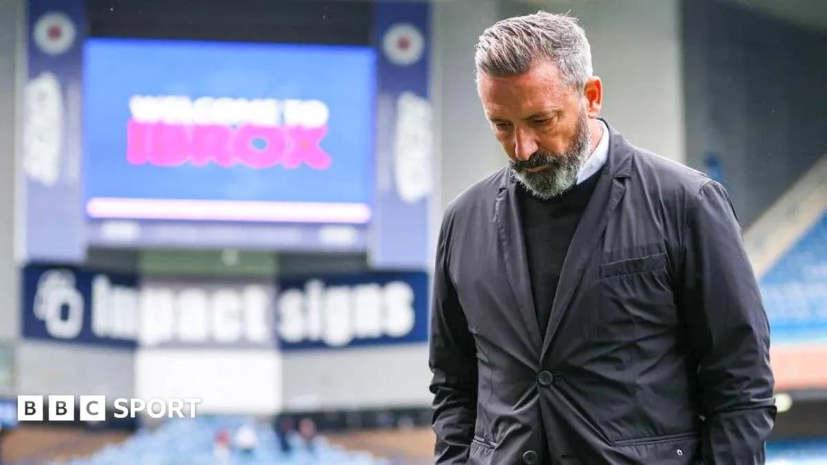 Men's football coach at Ibrox Stadium looking down